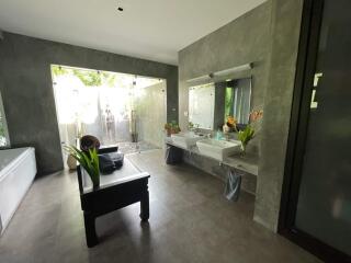 Spacious modern bathroom with double sinks and large glass shower