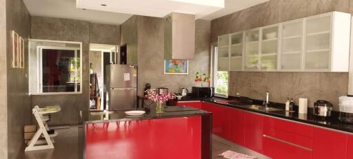 Modern kitchen with red cabinetry and stainless steel appliances