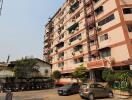 Exterior view of a multi-story residential building with parking area