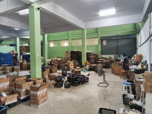 Warehouse interior with boxes, shelves, and workers