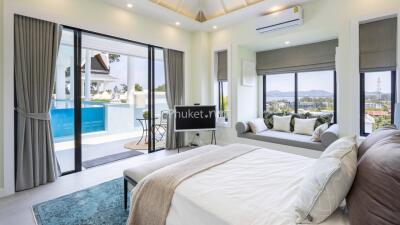 Spacious bedroom with large windows and a view of the pool area