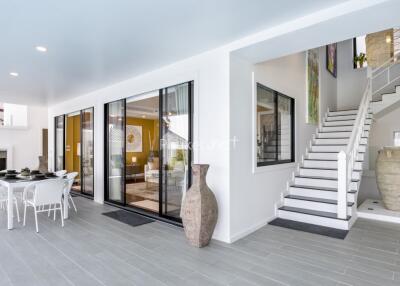 Modern open concept living area with stairway and dining space