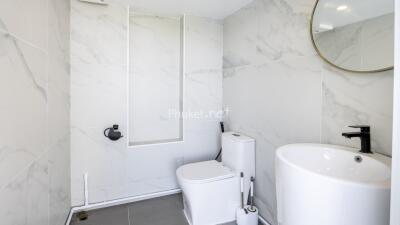 Modern bathroom with a toilet, sink, and mirror