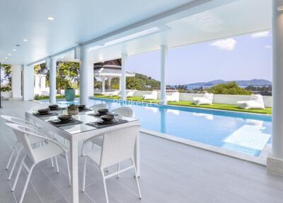 Elegant outdoor dining area next to a luxurious swimming pool with scenic views