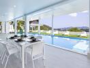 Elegant outdoor dining area next to a luxurious swimming pool with scenic views