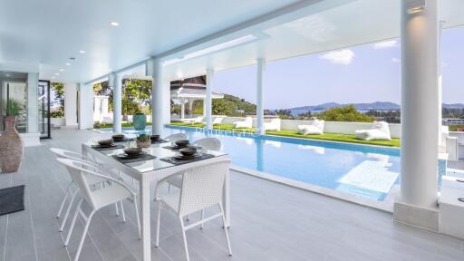 Elegant outdoor dining area next to a luxurious swimming pool with scenic views