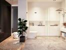 Modern bathroom with black wardrobe, large glass shower, potted plant, and floating vanity