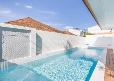 Swimming pool with marble tiles and wooden deck