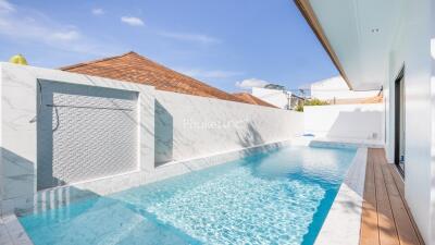 Swimming pool with marble tiles and wooden deck