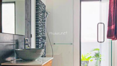 Modern bathroom with sink, shower, and large window