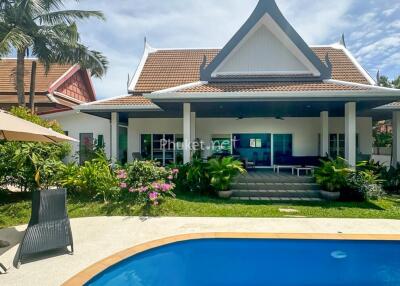 Exterior view of a house with a swimming pool and a garden