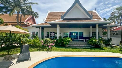 Exterior view of a house with a swimming pool and a garden