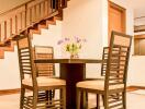 Dining area with table and four chairs next to a wooden staircase