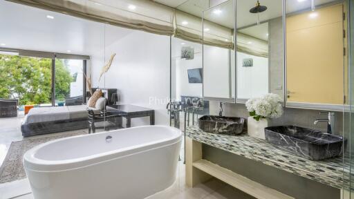 Modern bathroom with double vanity and bedroom in the background