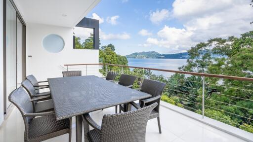 Outdoor dining area with a view of the sea and surrounding greenery