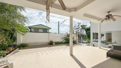 Spacious outdoor patio with ceiling fans, car parking, and garden area