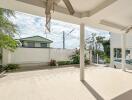 Spacious outdoor patio with ceiling fans, car parking, and garden area