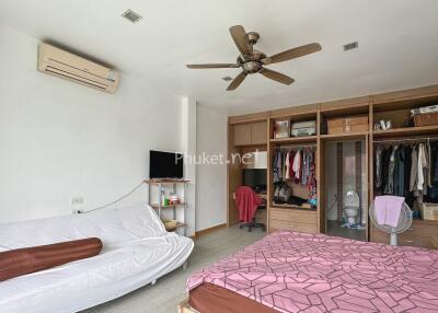 Spacious bedroom with wardrobe, sofa, and ceiling fan