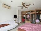 Spacious bedroom with wardrobe, sofa, and ceiling fan