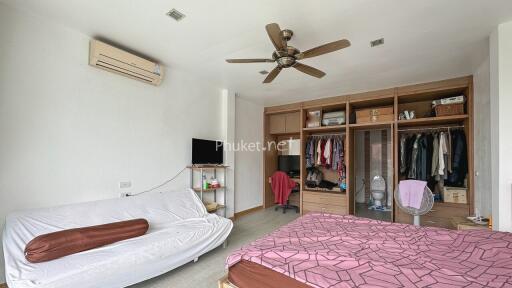 Spacious bedroom with wardrobe, sofa, and ceiling fan