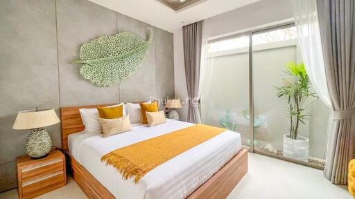 Modern bedroom with large bed, decorative leaf wall piece, and sliding glass door to patio