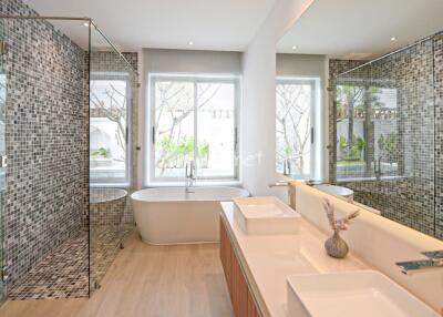 Modern bathroom with dual sinks, bathtub, and walk-in shower