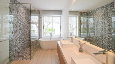 Modern bathroom with dual sinks, bathtub, and walk-in shower