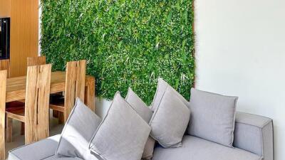 living room with green wall and wooden dining set