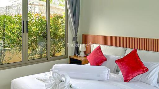 Comfortable bedroom with large window and red accent pillows