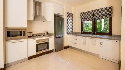 Modern kitchen with stainless steel appliances and large windows