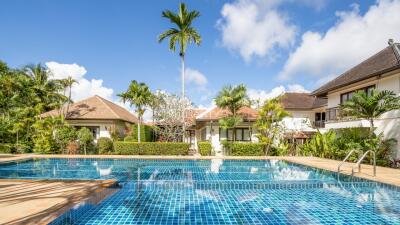 Luxurious pool area with palm trees and villas