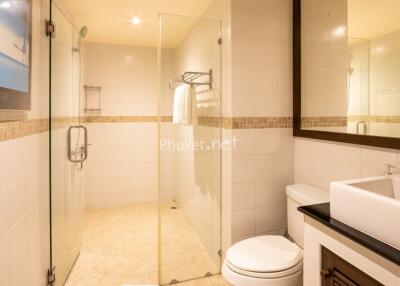 Modern bathroom with glass shower, sink, and toilet