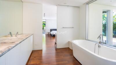 Modern bathroom with a bathtub, double sink vanity, and natural light