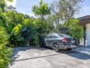 Driveway with car and lush greenery