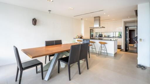 Modern kitchen and dining area with wooden table and black chairs