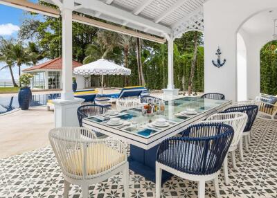 Outdoor dining area with pool and garden view