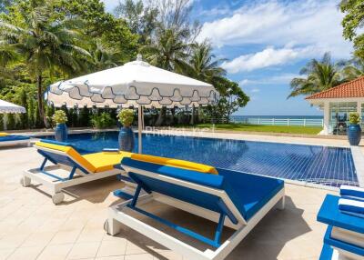 Outdoor pool area with loungers and umbrella