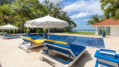 Outdoor pool area with loungers and umbrella