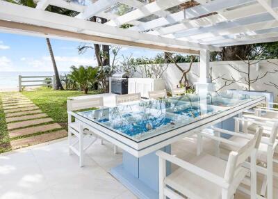 Outdoor patio with glass dining table and white chairs