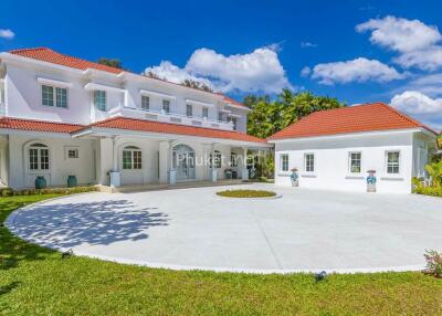 Elegant white house with red tiled roof and spacious driveway