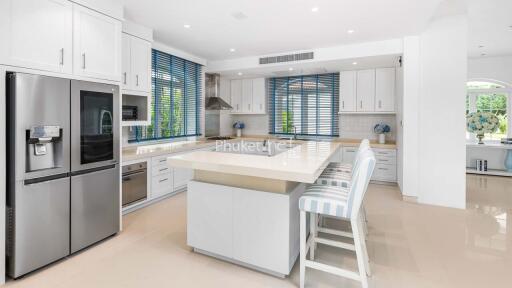 Modern kitchen with white cabinetry, island and stainless steel appliances