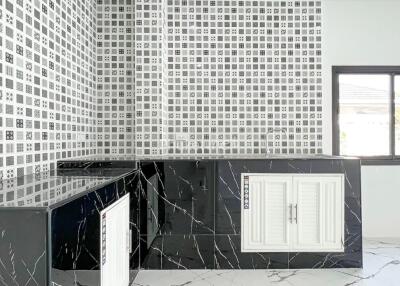 Modern kitchen with black marble countertops and mosaic tile backsplash