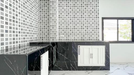 Modern kitchen with black marble countertops and mosaic tile backsplash