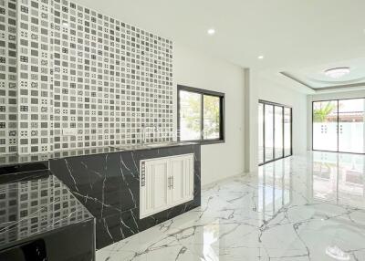 Modern living area with patterned accent wall and marble flooring