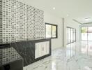 Modern living area with patterned accent wall and marble flooring