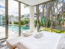 Spacious bedroom with large glass windows offering a view of the pool and garden