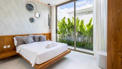 Modern bedroom with large window and plants outside