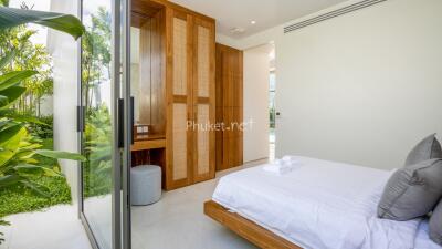 Modern bedroom with large windows and garden view