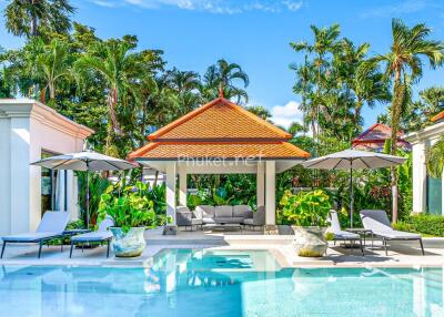 Beautiful outdoor swimming pool area with lounge chairs and greenery