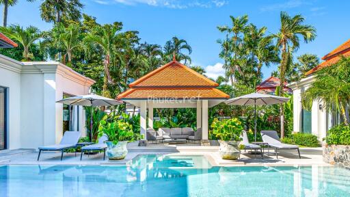 Beautiful outdoor swimming pool area with lounge chairs and greenery